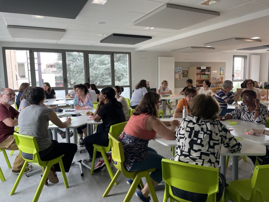 Des salariés assis à des tables pour un atelier sur la rencontre